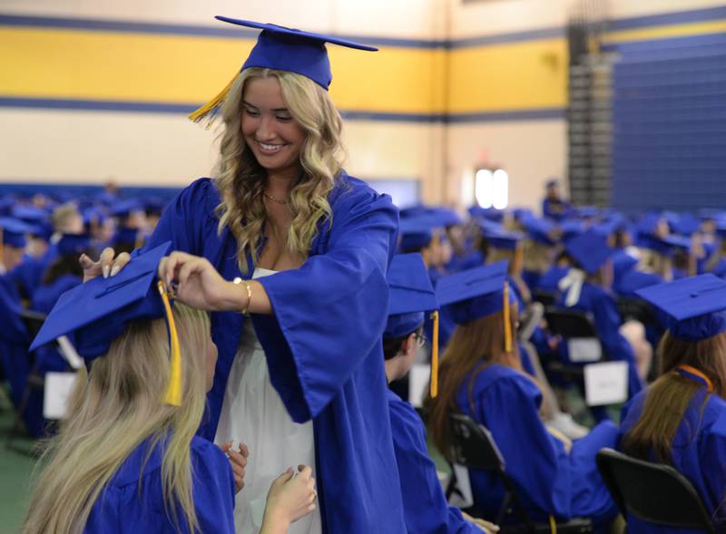 Lyons Township student Tatiana Zecevic of Burr Ridge helps Elena Janeva of Willow Springs with her cap prior to their graduation ceremony Wednesday May 29, 2024.