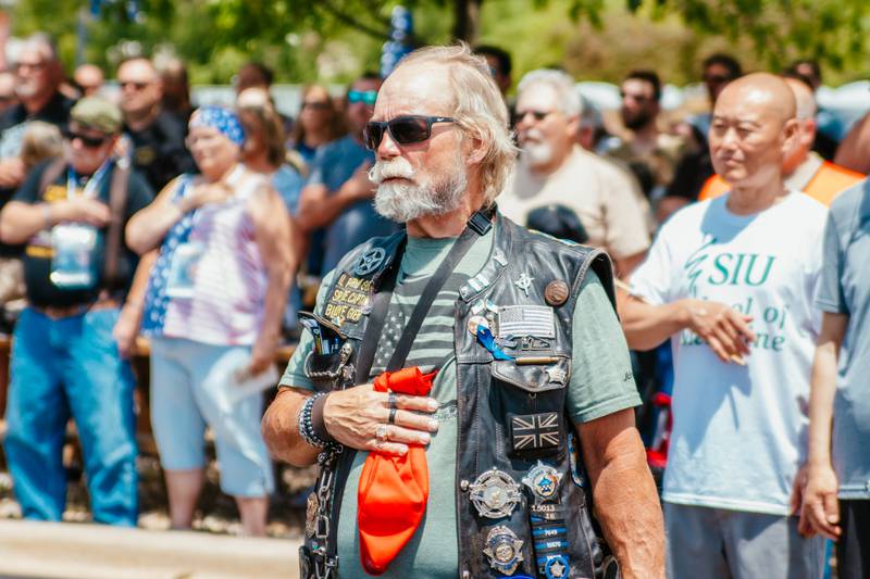 A motorcyclist puts his hand on his heart for performance of the "Star Spangled Banner" on Saturday, June 15, 2024, during the Illinois Motorcycle Freedom Run at the Middle East Conflicts Wall in Marseilles.