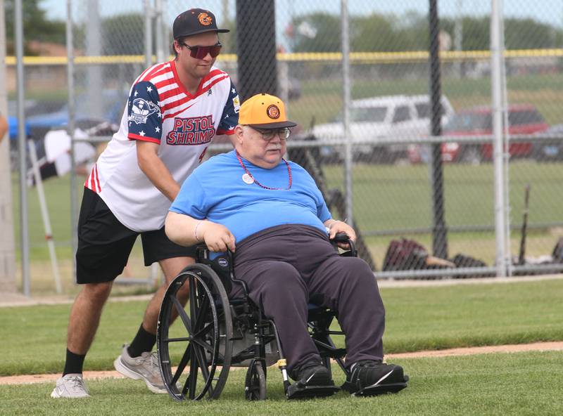 Terry Rasso, a World War II Air Force pilot Veteran, is pushed out to the mound by Pistol Shrimp's Finley Buckner  to throw out the honorary first pitch on Wednesday, July 3, 2024 in Schweickert Stadium at Veterans Park in Peru. The Pistol Shrimp held their annual Salute to Veterans honoring local members who served in the military.