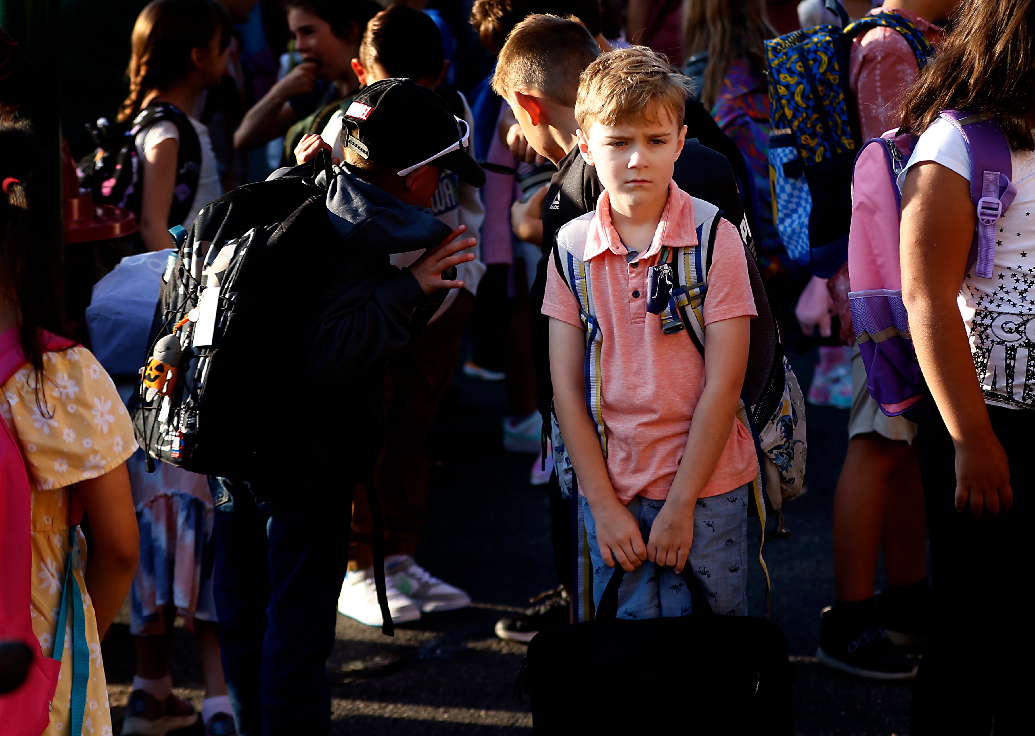 Third-grader Adam Zmuda waits for school to start with other students on the first day of school at Olson Elementary School in Woodstock on Wednesday, Aug. 14, 2024,