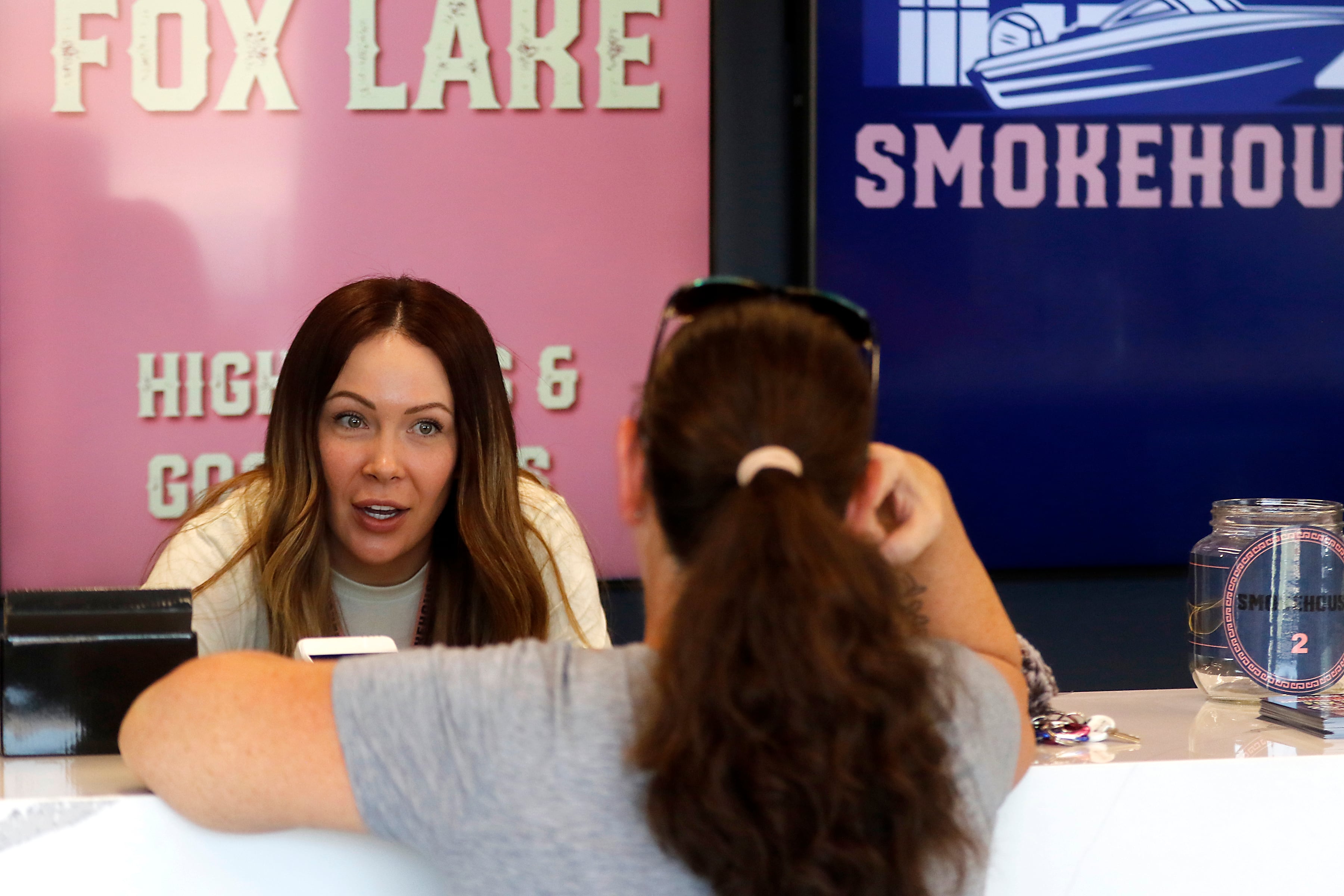 Smokehouse Agent in Charge Madeline Morgan helps a customer at Illinois’ first dispensary located right on the water in Fox Lake on Friday, July 25, 2024. The dispensary located at 44 U.S. Route 12, features boat slips so customers on the Fox River and Chain o' Lakes can boat right up to the dispensary.