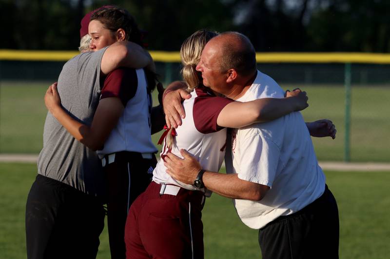 Marengo coach Rob Jasinski, left, embraces Marissa Young and Head Coach Dwain Nance embraces Lilly Kunzer after a loss to North Boone in IHSA Softball Class 2A Regional Championship action at Marengo Friday.