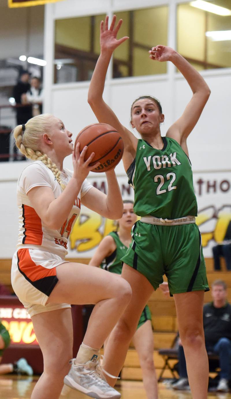 St. Charles East’s Addie Schlib, left, drives to the basket against York’s Stella Kohl during the semifinal of the Montini girls basketball tournament Thursday December 28, 2023 in Lombard.