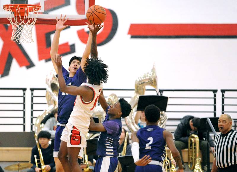 Plano's Isaiah Martinez (23) defends a shot by Yorkville's Kaevian Johnson during a varsity basketball game at Yorkville High School on Tuesday, Dec. 19, 2023.