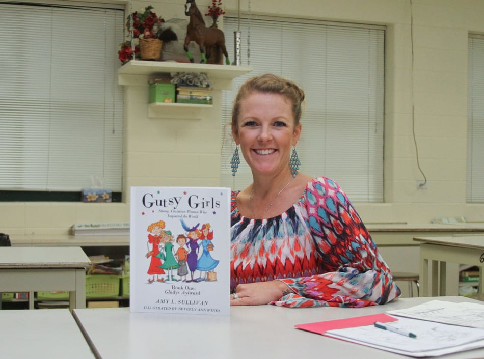 Minooka Junior High art teacher Beverly Wines shows off the first in a series of books she has created with her cousin, author Amy Sullivan.