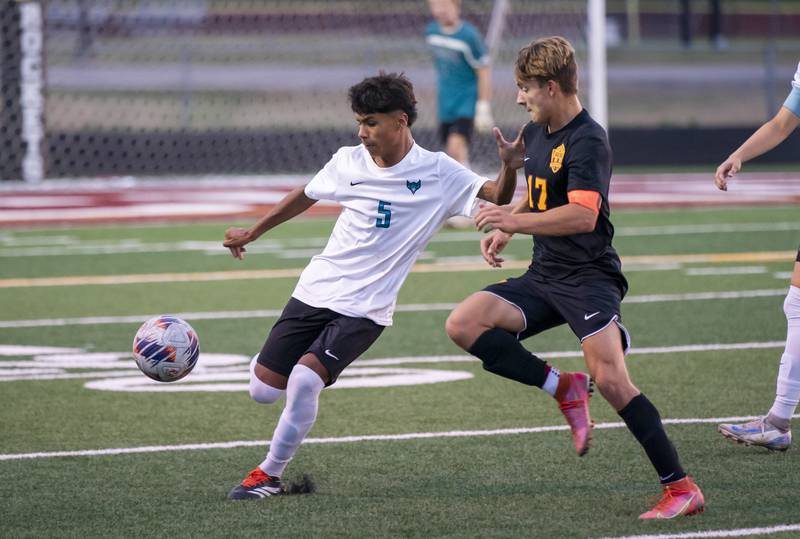 Woodstock North's Saul Santana, center, holds off Richmond-Burton's Joe Kyes during their varsity soccer game on Wednesday, September 18, 2024 at Richmond-Burton High School in Richmond.