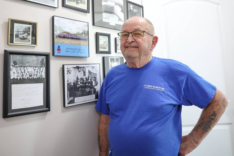Jim McElroy stand by his photos of his time in the Navy along with his 113th Honor Flight Chicago group photo on Tuesday, May 21, 2024.