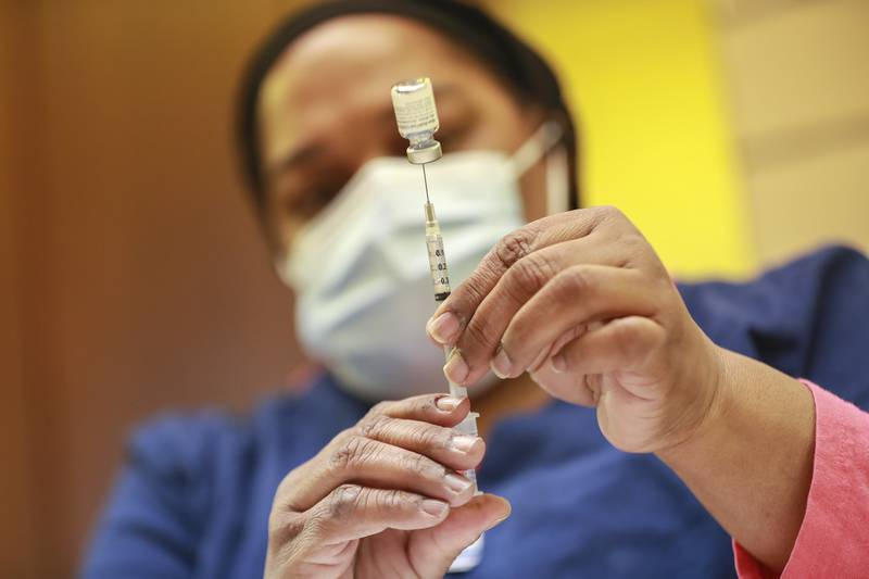 Brenda Alexander draws syringes with a dose of the Pfizer COVID-19 vaccine on Friday, March 26, 2021, at St. Rose Church in Wilmington, Ill.