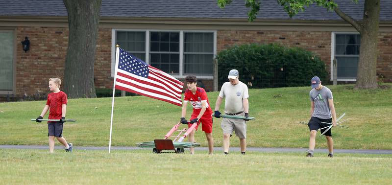 Volunteers set up for the Field of Honor, a display of 2,024 American flags arranged in 25 neat rows Saturday, June 29, 2024 at Seven Gables Park in Wheaton.