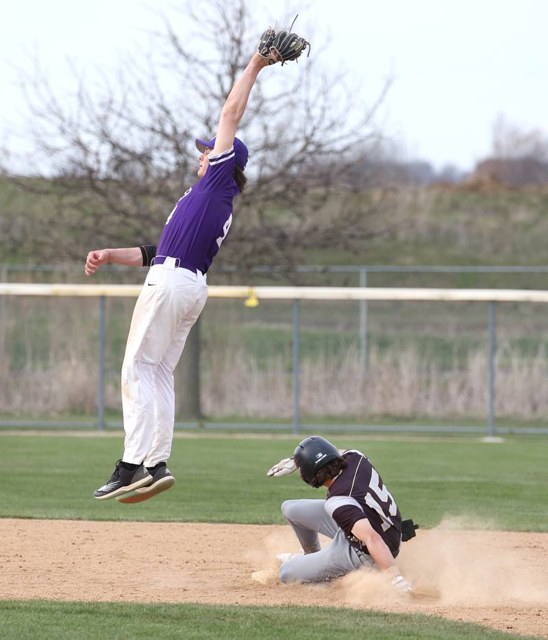 Sycamore's Will Klumpp slides in with a stolen base as Rochelle's Brock Metzger tries to come up with the high throw during their game Wednesday, April 10, 2024, at Rochelle High School.