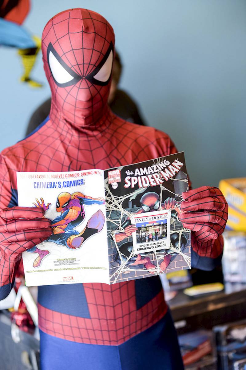 Spider-Man reads about his latest adventures during Free Comic Book Day on Saturday at Chimera's Comics in Woodridge.