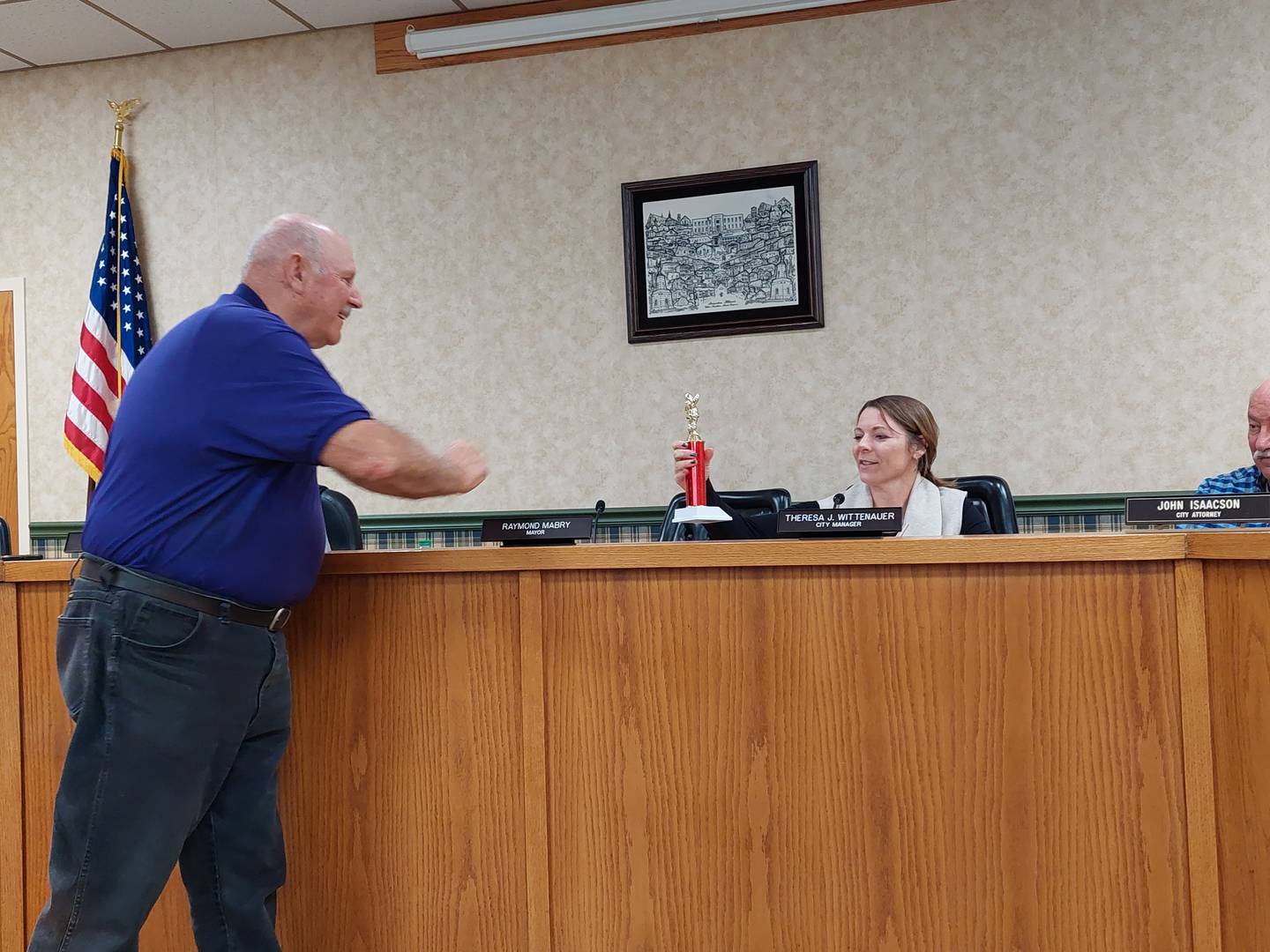 Princeton Lions Club member Jim Argo hands a trophy Monday, Dec. 4, 2023, to Princeton City Manager Theresa Wittenauer for the electric department's winning float in the government category of the lighted Christmas parade.