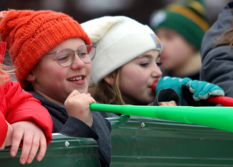 Annika Edlund, left, 10, and Teresa Myhra, 10, toot their toy horns as they wait for jumpers to begin during the 119th Norge Annual Winter Ski Jump Tournament in Fox River Grove Sunday. Edlund’s dad David Edlund competed for the St. Paul Ski Club on Sunday.