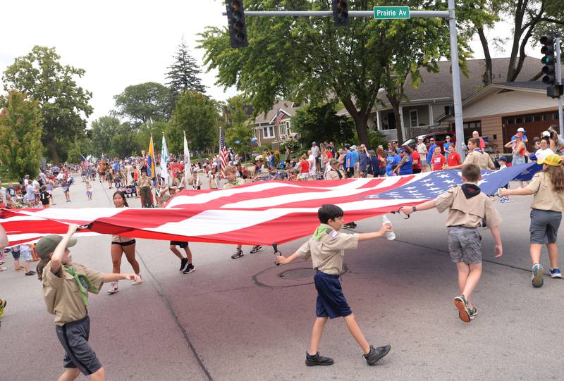 Downers Grove boy scouts circle the flag around while participating in the Downers Grove Fourth of July Parade on Thursday, July 4, 2024.