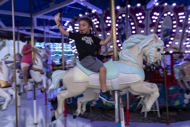 Khalil Rice waves at his father while riding the merry-go-round at Streatorfest on August 2. 2024.