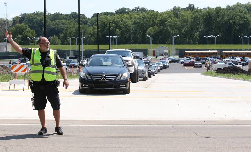 An Ottawa Police officer directs traffic on Thursday, Aug. 8, 2024 at Ottawa High School.