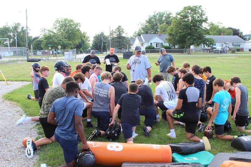 Flanagan-Cornell/Woodland football coach Todd Reed (standing at center) talks things over with his Falcons during FCW's first summer camp day Monday, July 22, 2024, in Flanagan.