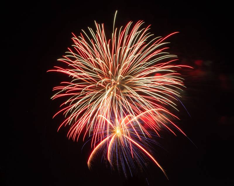 Attendees sit and watch the Elburn Lions Club Fireworks at Lions Park in Elburn on Saturday, July 8, 2023.