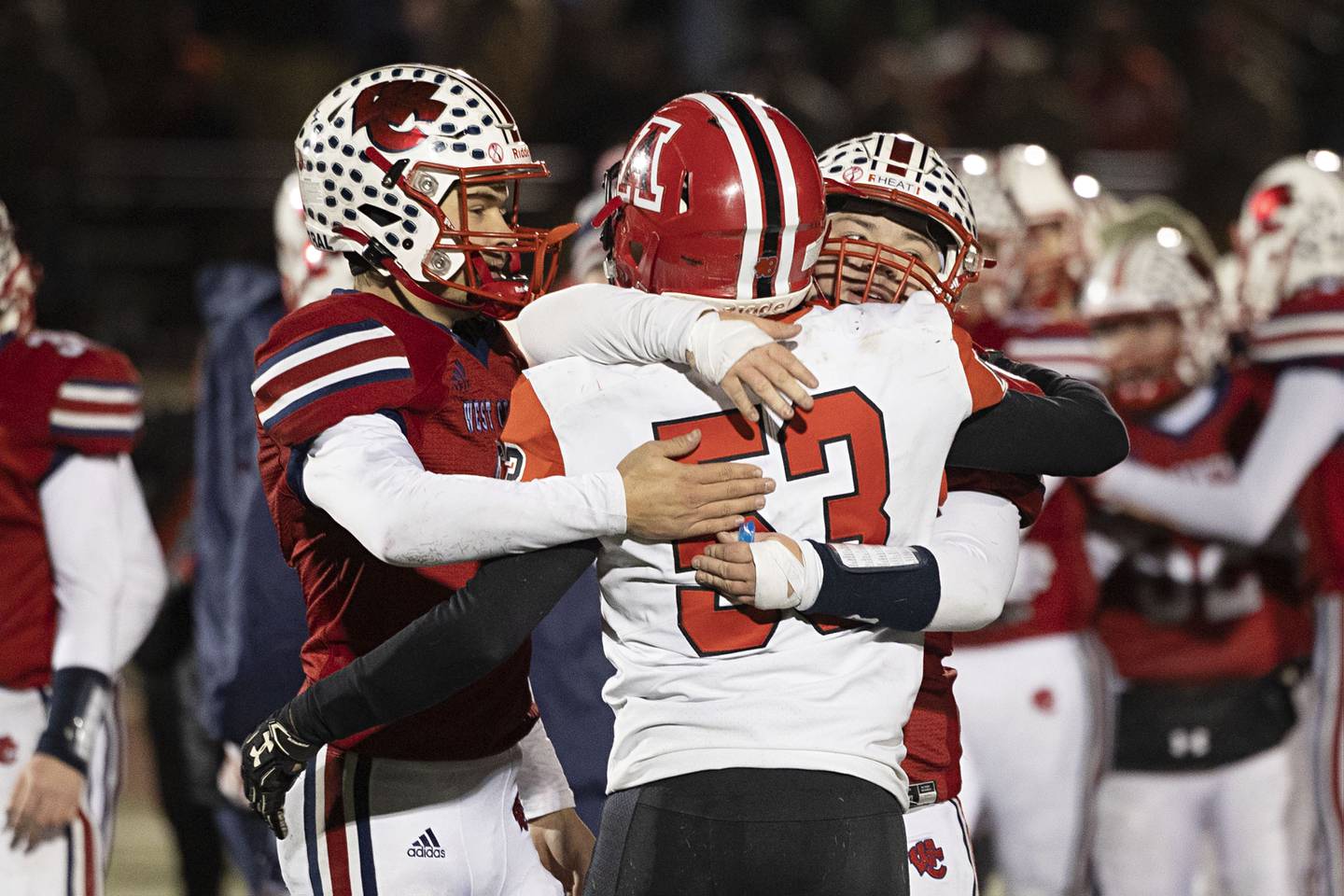 Amboy’s Austin Heath embraces members of the West Central football team after a hard fought game resulted in a 44-36 win for West Central in the 8-man championship game Friday, Nov. 18, 2022.