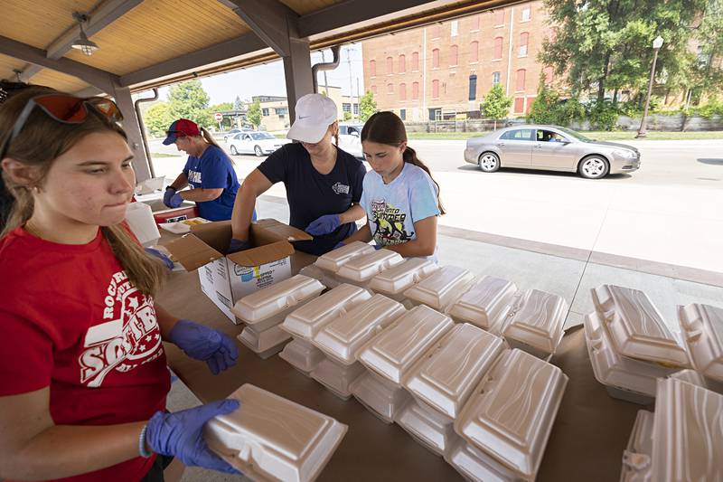 Brittany Whitman (left) working with the Impact Program at Sauk Valley College volunteers Monday, July 24, 2023 at the Rotary Club’s Corn Boil and BBQ Pork Chop sale.