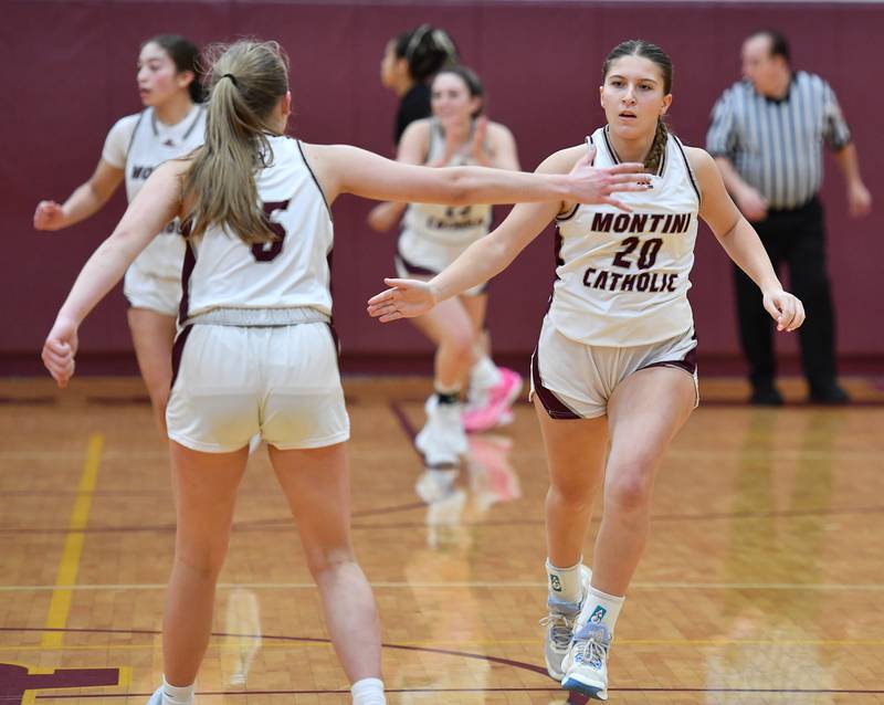 Montini's Lily Spanos (20) is greeted at mid court by teammate Victoria Matulevicius after sinking a big three pointer at the end of the third quarter of the Montini Christmas Tournament championship game against St. Charles East on Dec. 29, 2023 at Montini Catholic High School in Lombard.