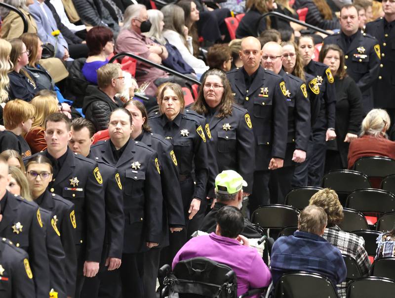 Members of the DeKalb County Sheriff’s Department file by the casket of co-worker Deputy Christina Musil Thursday, April 4, 2024, during her visitation and funeral in the Convocation Center at Northern Illinois University. Musil, 35, was killed March 28 while on duty after a truck rear-ended her police vehicle in Waterman.