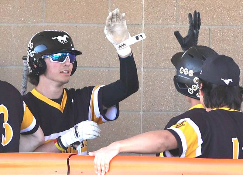 Jeremy Wrona (left) is congratulated after hitting a sacrifice fly scoring a runner from third during their game against DeKalb Thursday, April 13, 2023, at DeKalb High School.