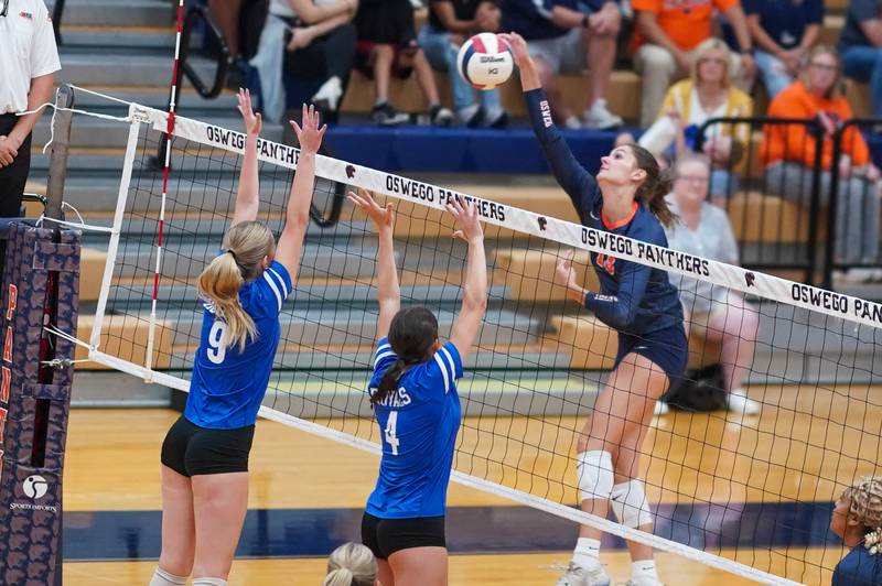 Oswego’s Sidney Hamaker (13) goes up for a kill attempt against Rosary’s Aerin Leonard (9) and Reese Gilla (4) during a volleyball match at Oswego High School on Tuesday, Sep 3, 2024.