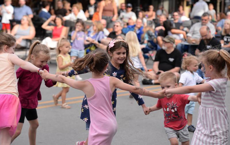 Children including Juliet Gibson of Glen Ellyn spin to the sounds of Altered Suburbia during the concert held downtown Glen Ellyn Friday June 8, 2024.