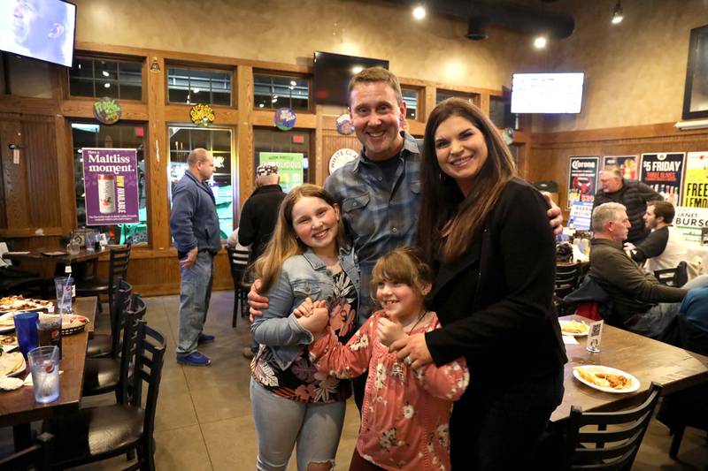 Nicolas Boatner, candidate for Campton Hills trustee, poses for a photo with his wife, Kim, and daughters Cecelia, 11, and Charlotte, 7, at the Old Towne Pub in Campton Hills as they await election results following the Consolidated Election on Tuesday, April 4, 2023.