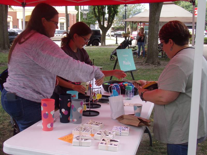 Mady Olszewski, of Ottawa, makes a sale Saturday, Aug. 13, 2022, from her business Vinyltastic by Mady during the Ottawa Children's Business Fair in Washington Square.