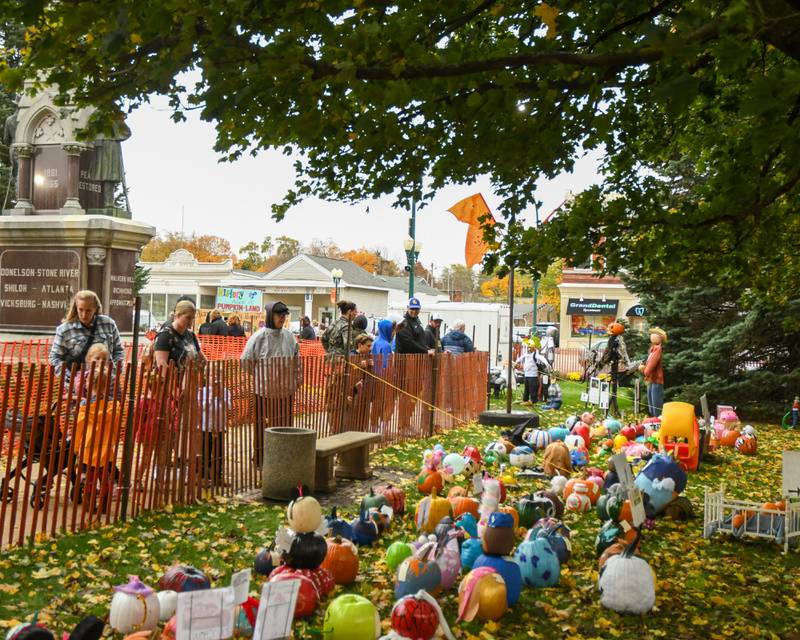 Community members walk around the pumpkins on display on the Sycamore courthouse lawn on Friday Oct. 27, 2023, during the Sycamore Pumpkin Festival.