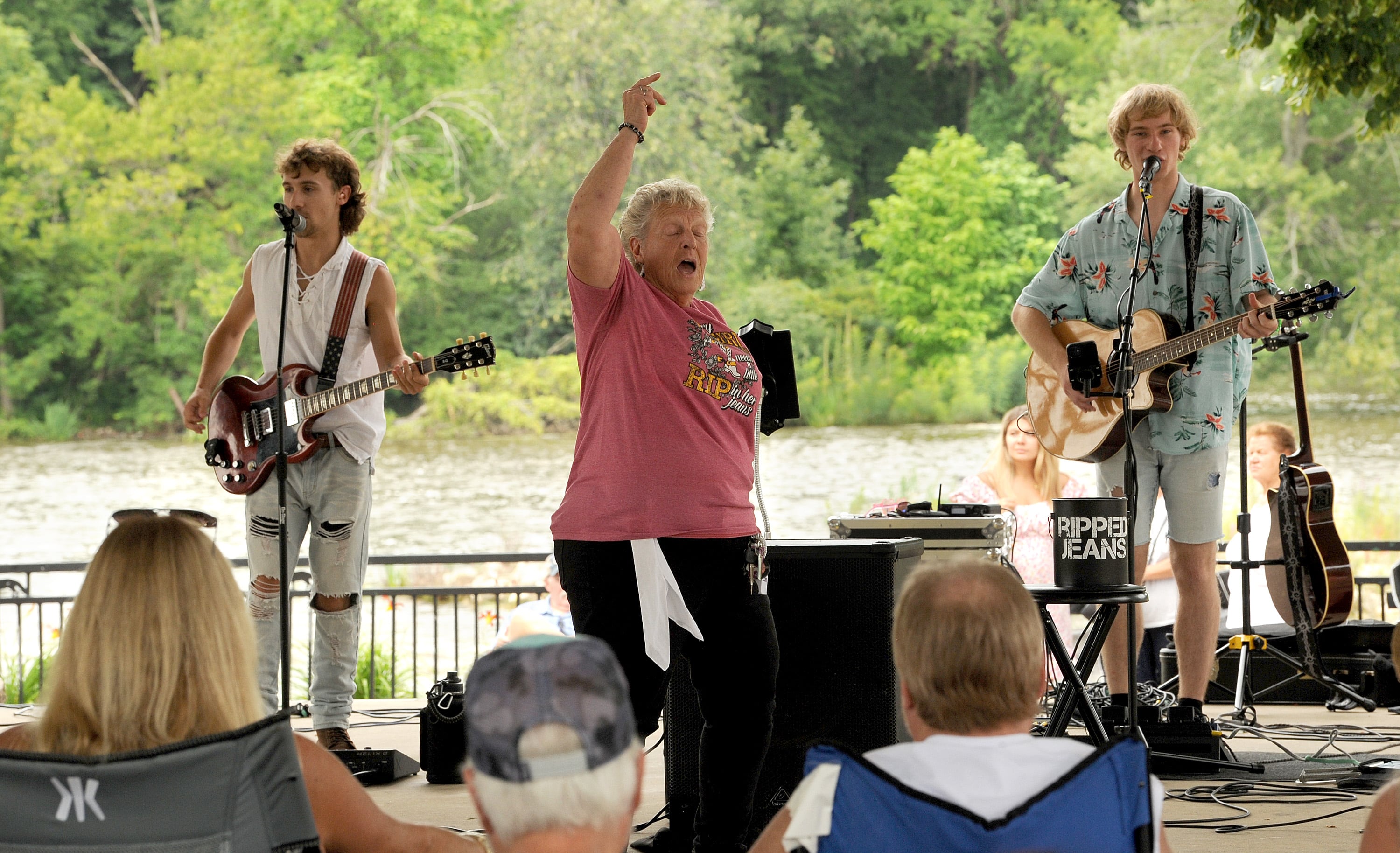 Flanked by members of Ripped Jeans, Sheila Palmatier, aka the Dancing Queen, gets into the music during Riverfest on Hydraulic Avenue in Yorkville on Saturday, July 20, 2024.