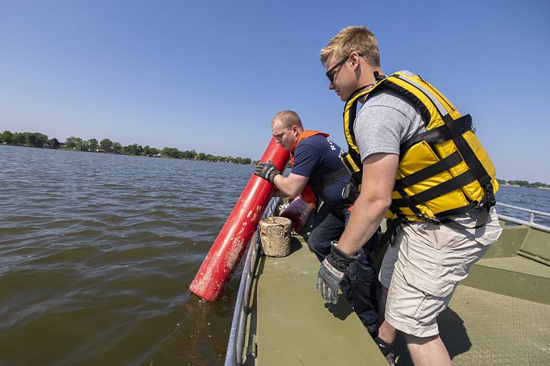 Dylan Scudder drops the next buoy Wednesday, May 15, 2024 in the Rock River. The floats are colored red and green to mark the edges of the channel. When traveling upstream, red is on the right and green on the left.