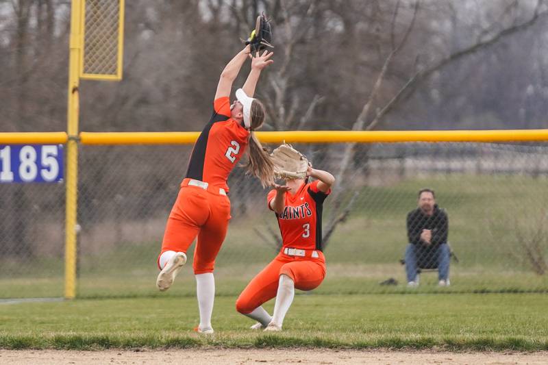 St. Charles East's Addison Wolf (2) makes a catch for out right before colliding with left fielder Eden Corcoran (3) during a softball game against Oswego East at Oswego East High School on Wednesday, March 13, 2024.