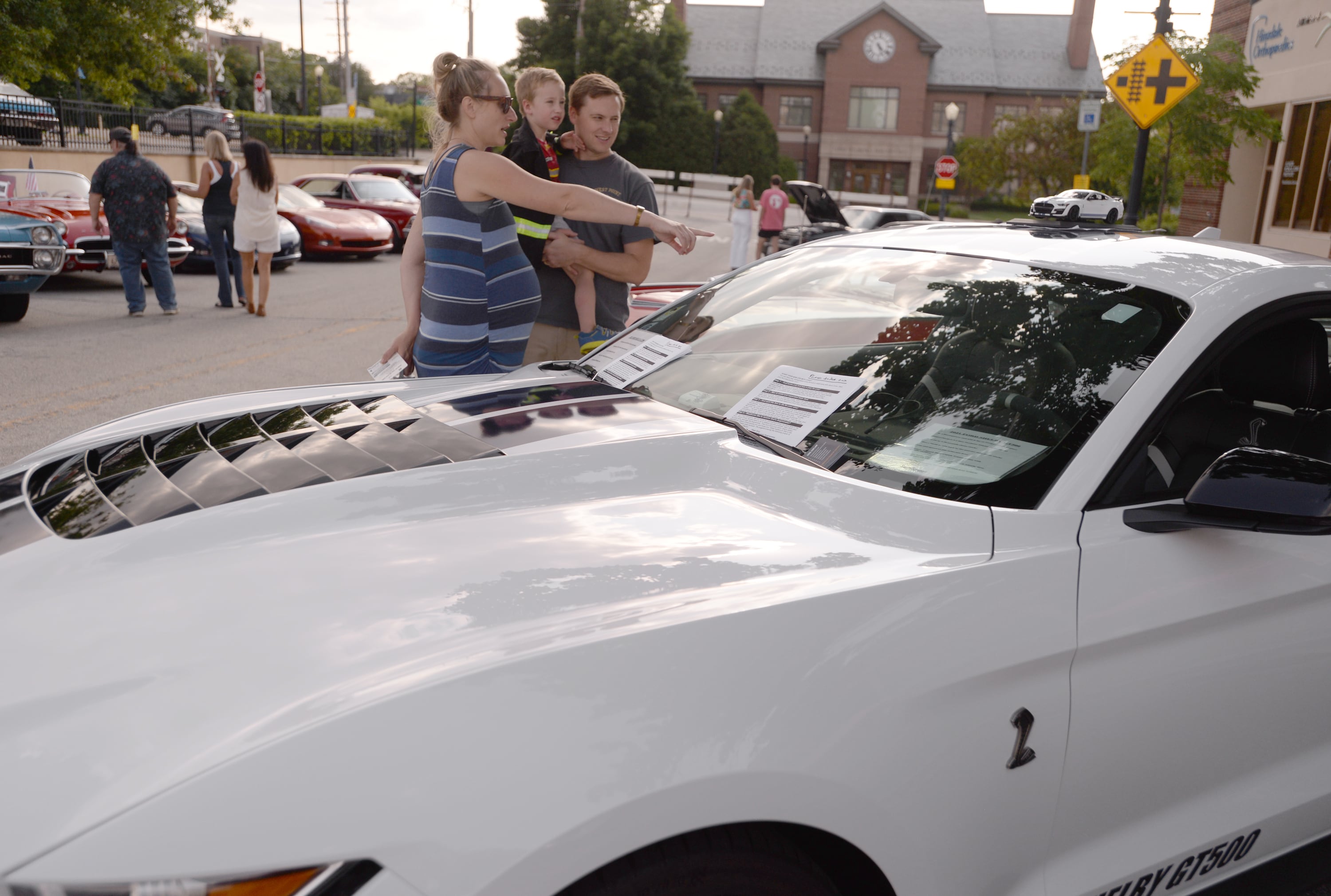 Sandra, Tom and their son Benedict Devane of Downers Grove take a look at a 2021 Ford Shelby GT500 during  the Downers Grove Car Show Friday July 19, 2024.