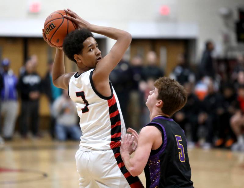 Bolingbrook’s Davion Thompson looks to pass the ball away from Downers Grove North’s Owen Thulin during the Class 4A East Aurora Boys Basketball Sectional final on Friday, March 1, 2024.