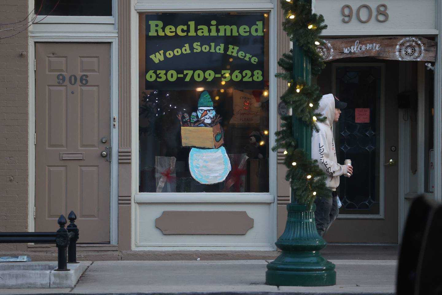 A snowman holds a box of wood in the window of The Old Wood Store in downtown Lockport on Friday, Dec.15th. Snowmen are painted on the window of 25 stores in downtown Lockport for the holidays.