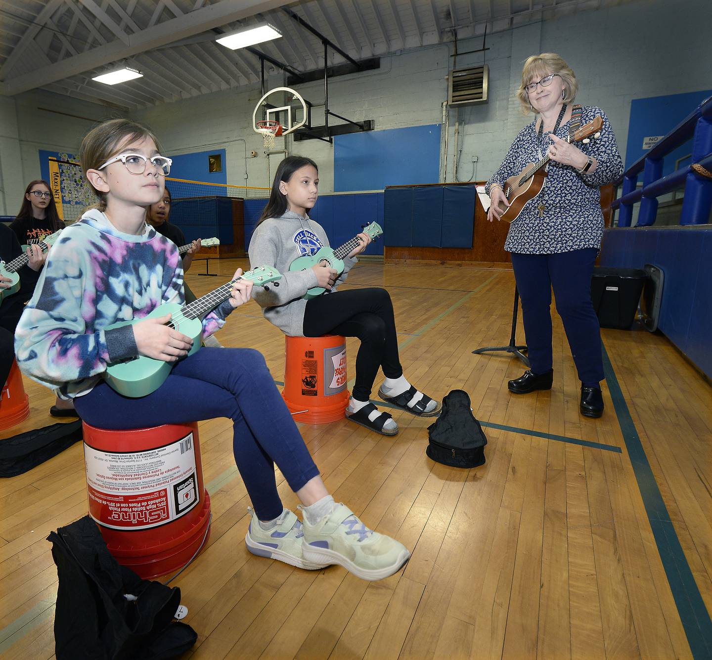 Dalzell Grade School music teacher Chris Kelsey leads 13 ukulele students in a song during a recent class Wednesday, March 15, 2023.