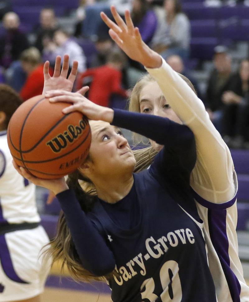 Cary-Grove's Sam Skerl tries to get a shot of as she is defended by Hampshire's Avery Cartee during a Fox Valley Conference girls basketball game Friday, Jan. 26, 2024, at Hampshire High School.