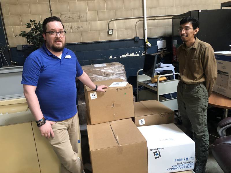 Zach Terrill, digital services librarian, and Adrian Mesino, marketing coordinator, with the low cost desktop and laptop computers available through PCs for People at the McHenry Public Library on Friday, May 31, 2024. People can apply online to purchase one of the computers and pick them up at the library.