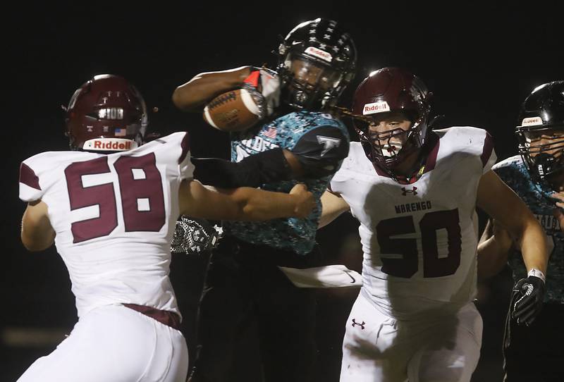 Woodstock North's Maxwell Dennison fights for yards against Marengo's Ryan Grismer (left) and Drew Litchfield (right) during a Kishwaukee River Conference football game on Friday, Sept. 13, 2024, at Woodstock North High School.