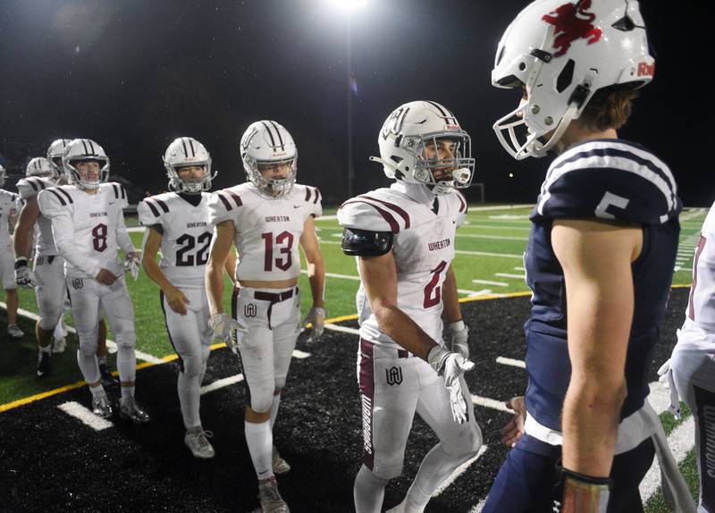 Joe Lewnard/jlewnard@dailyherald.com
Wheaton Academy's Brandon Kiebles (2) and his Warriors teammates line up to shake hands with St. Viator players including quaterback Cooper Kmet during Friday’s Class 4A football playoff in Arlington Heights Friday. Wheaton Academy won 12-3.