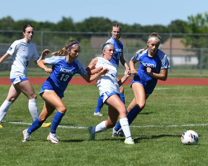 St. Charles North's Keira Kelly (8)  kicks the ball away while being defended by Wheaton North's Grace Kuczaj (13) and Caoah Strong (7)  during the sectional title game held on Saturday May 25, 2024 held at South Elgin High School.