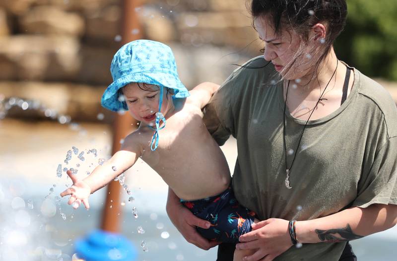 Jackson Garcia, 1, from Sycamore, reaches for the water with his mom Megan Tuesday, June 14, 2022, at the Sycamore Park District’s Splash Fountain. Temperatures reached nearly 100 degrees Tuesday and highs are expected to remain in the 90's through Thursday.