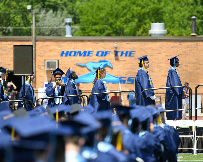 Downers Grove South High School seniors wait for their names to be called during the graduation held at Downers Grove South High School football stadium on Sunday May 19, 2024.