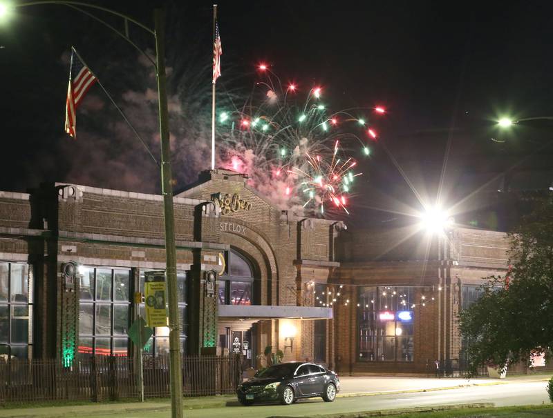 Fireworks glow above the Westclox building on Wednesday, July 3, 2024 along Water Street in Peru.