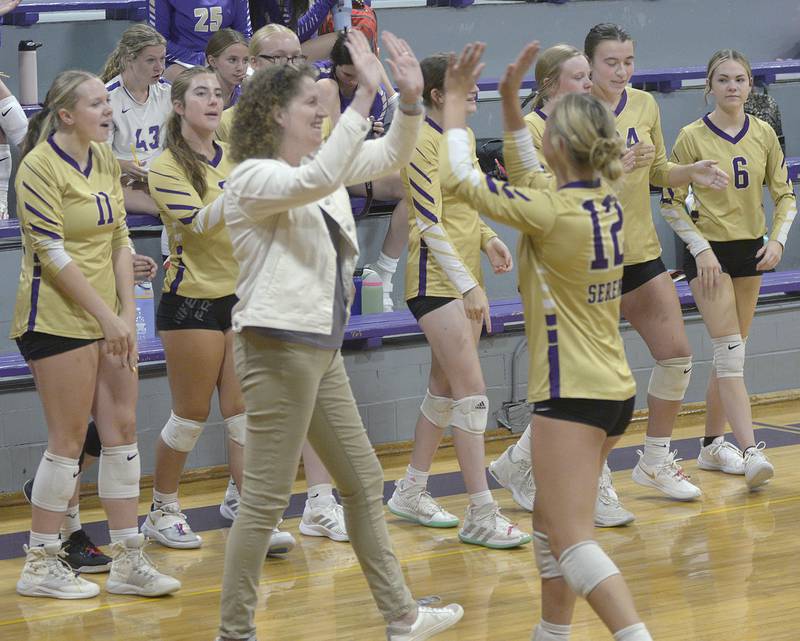 The Serena Huskers celebrate their point run during a timeout in the first set Tuesday against Woodland at Serena.