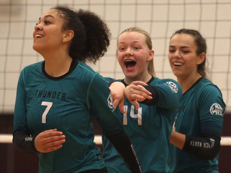 From left, Woodstock North’s Chloe Soto-Garcia, Devynn Schulze and Jayden Johnson celebrate a point in varsity volleyball on Monday, Sept. 16, 2024, at Richmond-Burton High School in Richmond.