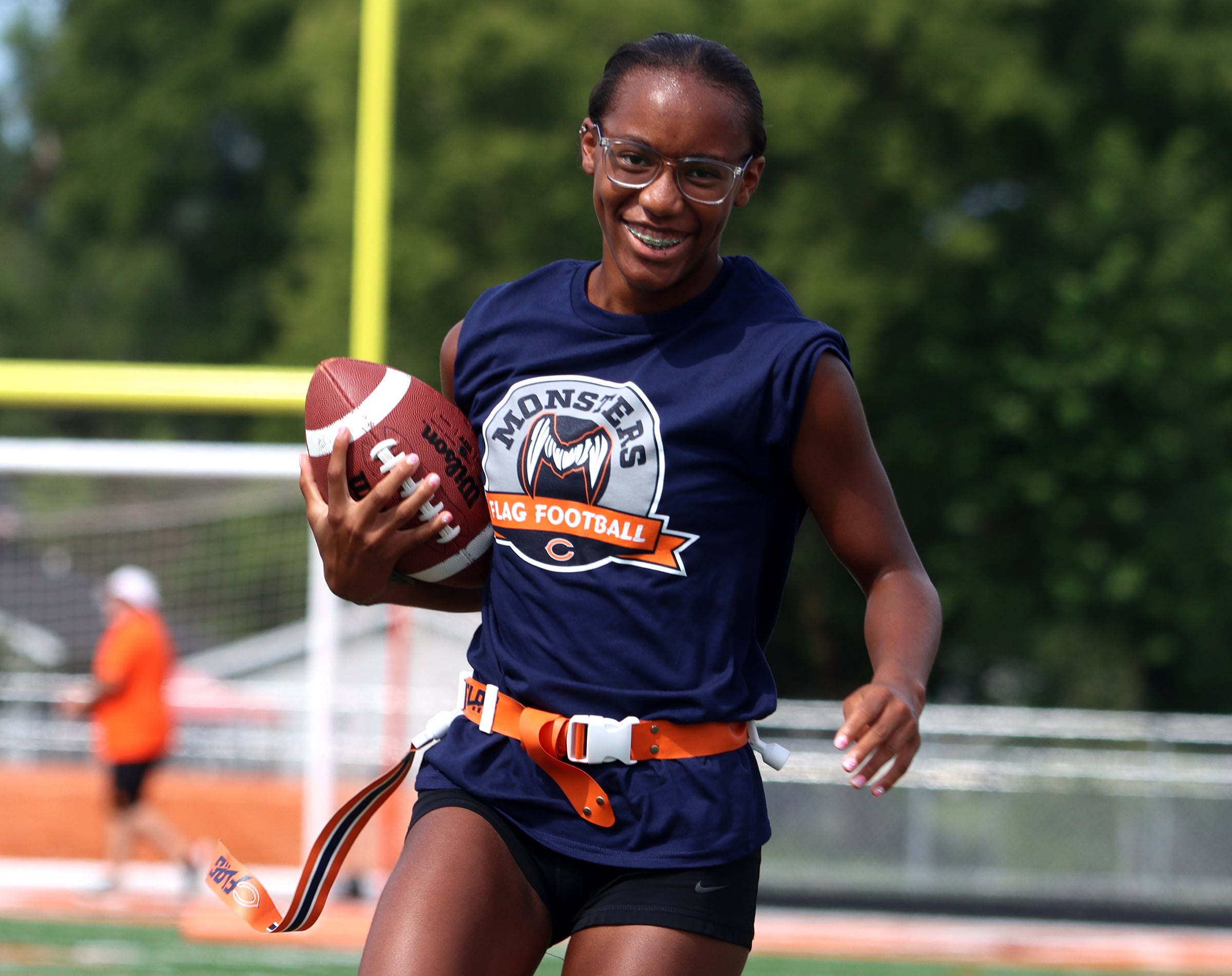 Jacobs High School sophomore Aaliyah Guichon grins while running the ball as the Chicago Bears and McHenry Community High School hosted a flag football clinic at McCracken Field Wednesday, July 31, 2024.